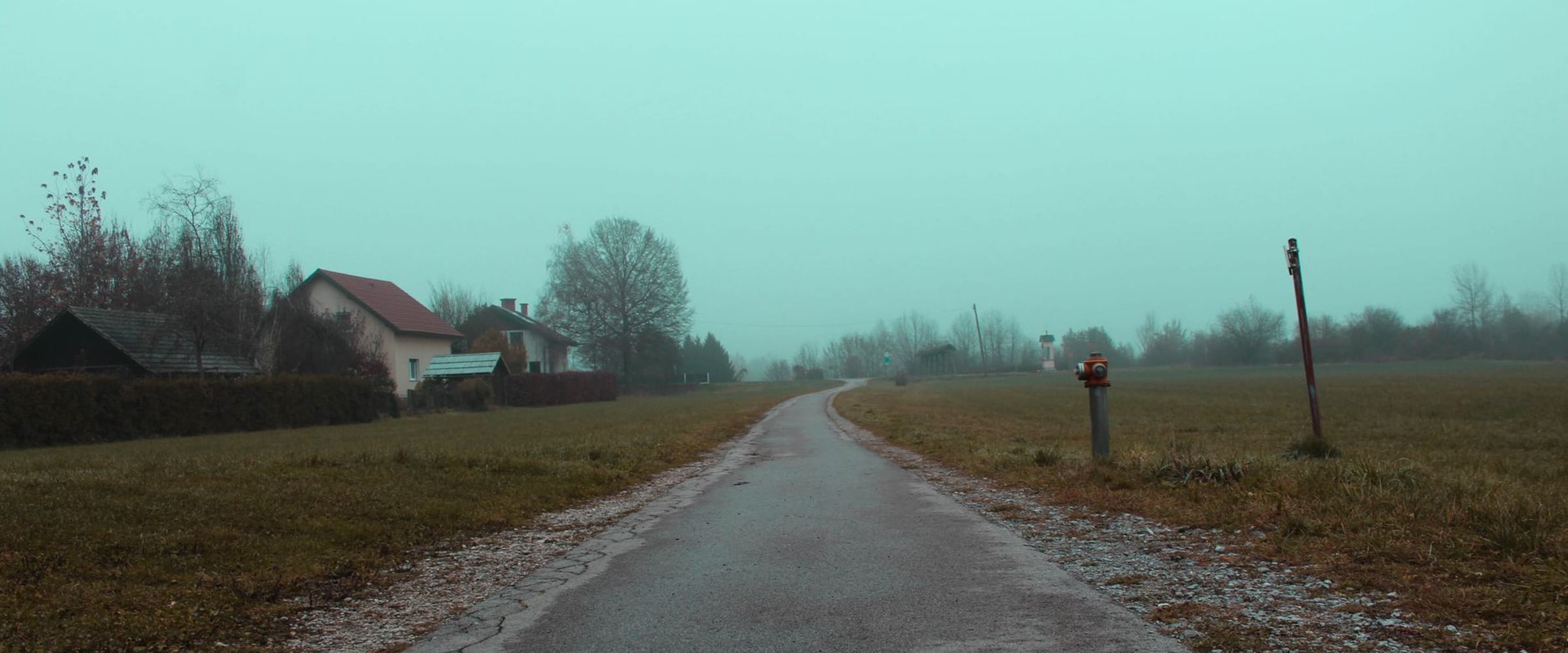 A calm, open road under a soft overcast sky.